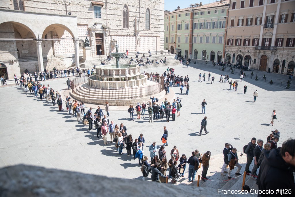 Folla in fila intorno alla fontana di Piazza IV Novembre a Perugia, durante il Festival Internazionale del Giornalismo 2025.